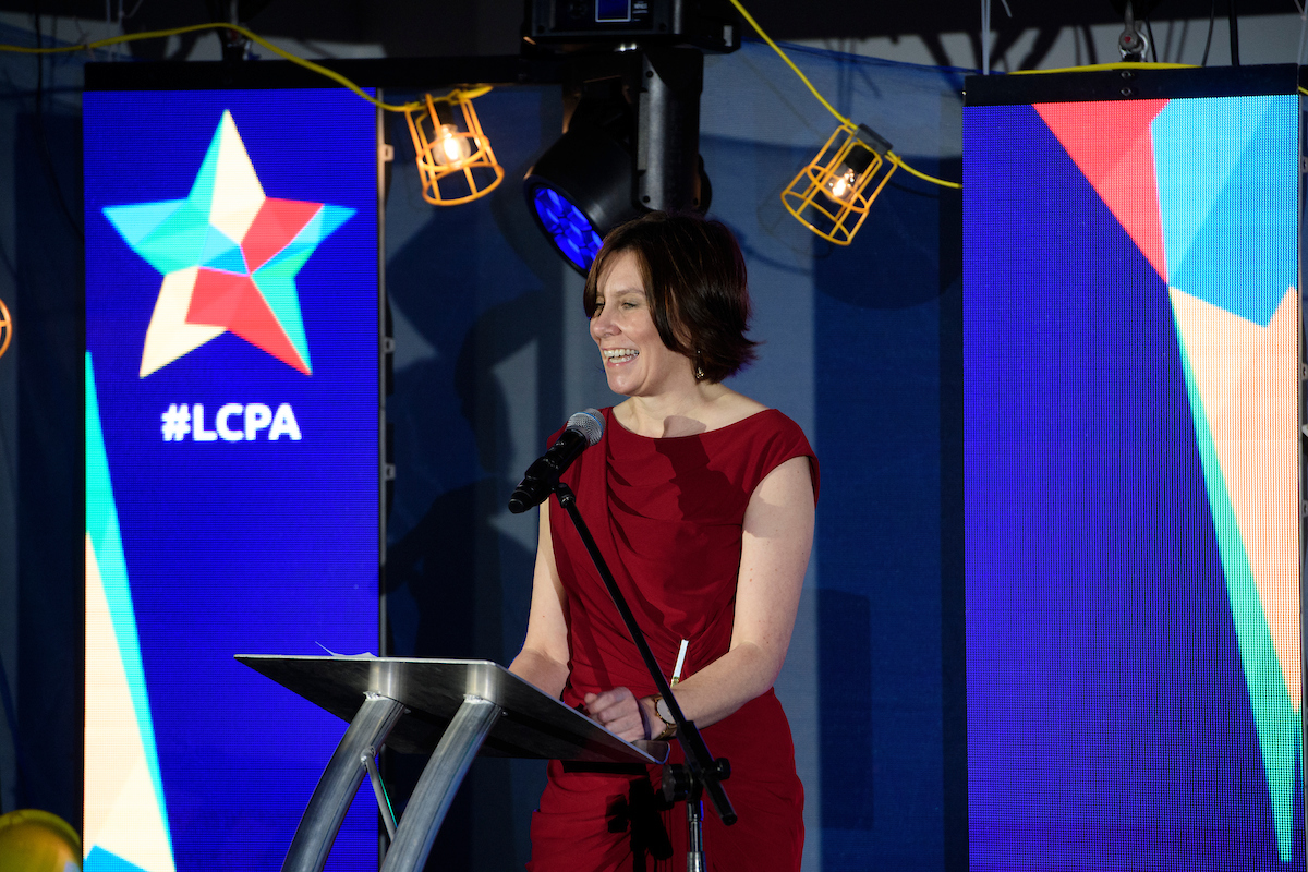 Caroline Killeavy, Chief Executive, YMCA Lincolnshire at The Greater Lincolnshire Construction and Property Awards 2020 wearing a red dress on stage