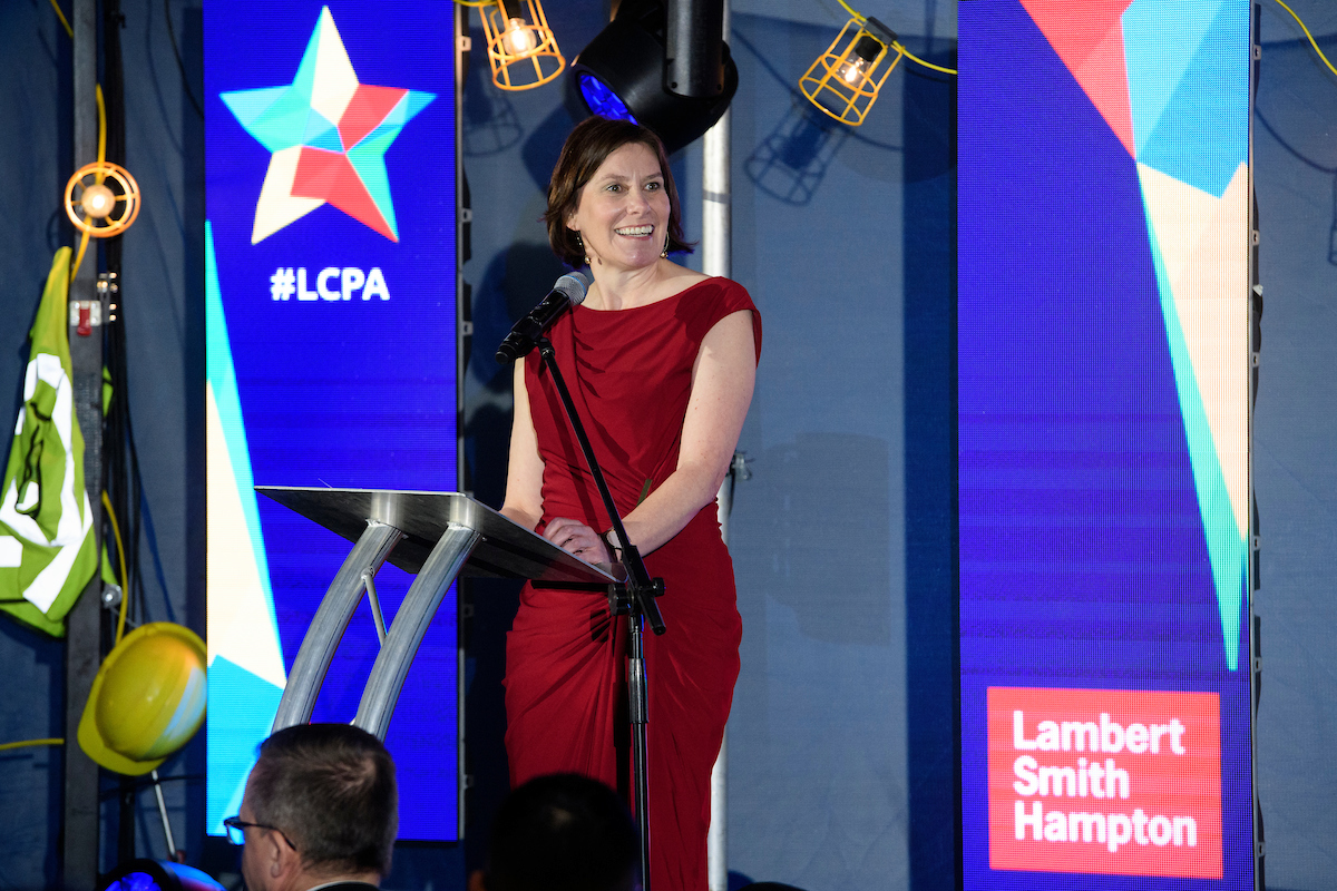 Caroline Killeavy, Chief Executive, YMCA Lincolnshire at The Greater Lincolnshire Construction and Property Awards 2020 wearing a red dress on stage