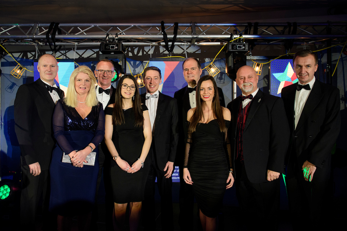 Picture of a group of people in formal evening wear, smiling