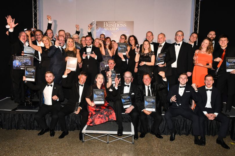 Picture of a group of people in formal evening wear sitting and standing at the Business Awards 2019