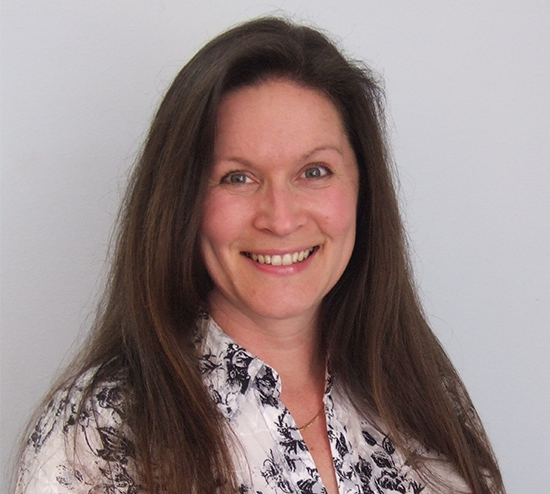 Woman with long brown hair wearing white top on grey background