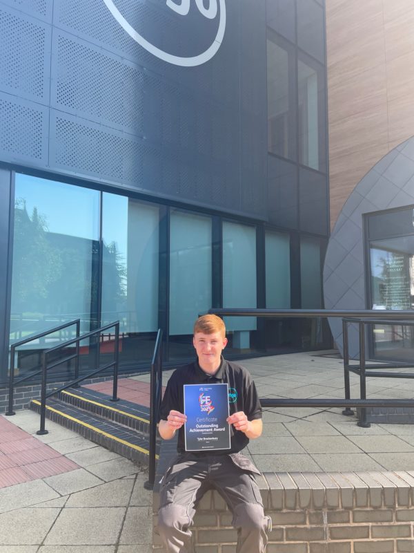 Young man holding certificate outside Ongo office