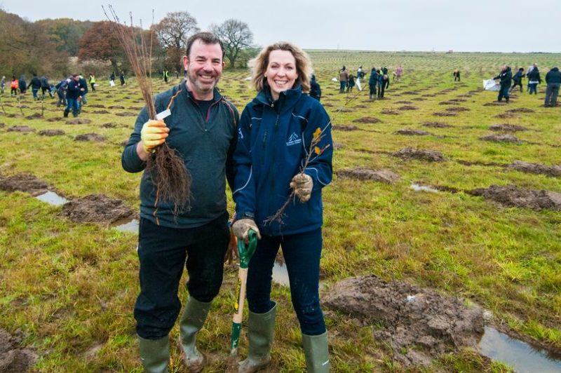 Man and woman in field planting trees. The man pictured is Paul Banton, MD at Ruddocks