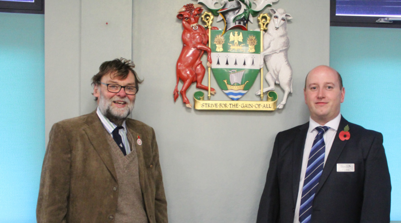 Cllr John McNeill and Cllr Stephen Bunney of West Lindsey District Council. A man with brown jacket, sweater vest and glasses smiling, with a man in suit and tie next to him