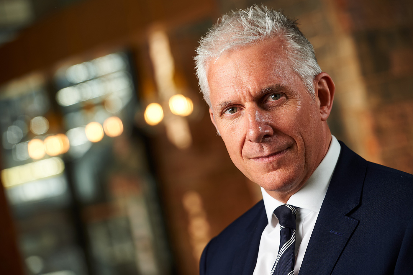 John Anderson, CEO of Larkfleet Group, a man with short silver hair wearing a black suit jacket, white shirt and tie