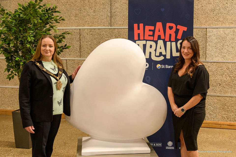 The Right Worshipful Mayor of Lincoln Jackie Kirk and Veronica McBain, Head of Fundraising and Lottery at St Barnabas Hospice. Two women standing in front of large white heart statue