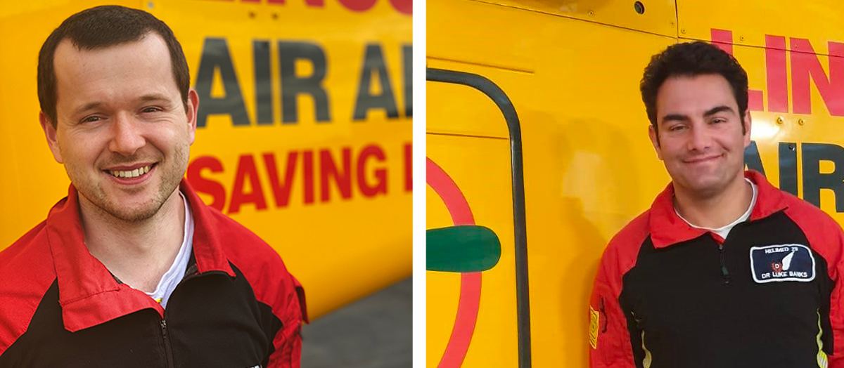 Two men in black and red uniforms in front of yellow helicopter, the Lincs & Notts Air Ambulance. The man on the left is Dr Luke Banks andand the man on the right HEMS Paramedic Alex Walker 