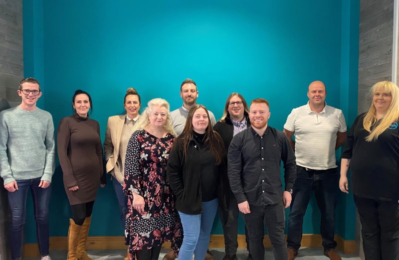 Group of people standing in front of blue wall