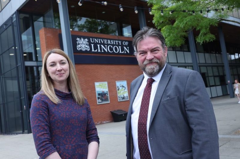 A man and woman wearing business attire outside of University of Lincoln