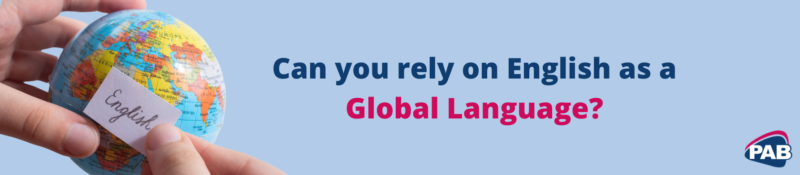 Blue background with person holding small globe and a white label with the word "English" on it. Dark blue and pink text "'Can you rely on English as a Global Language?" and PAB logo