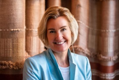 Shevaun Haviland, a blonde woman wearing light blue suit jacket, smiling at the camera