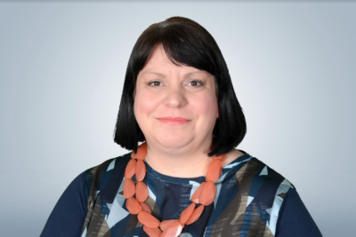 A woman with shoulder length dark hair looking at the camera