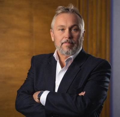 A smartly dressed business man folding his arms