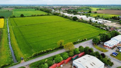 An aerial shot of a large field in the countryside. 