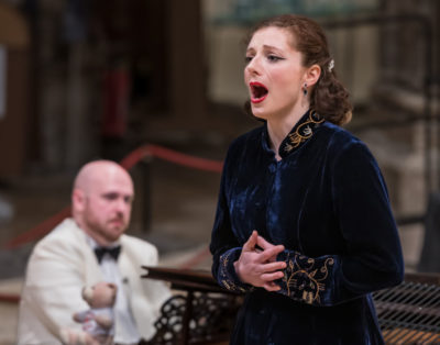 A woman singing indoors, in a cathedral. 